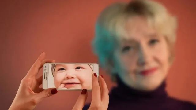 Older woman holding phone with baby photo representing biological vs chronological age