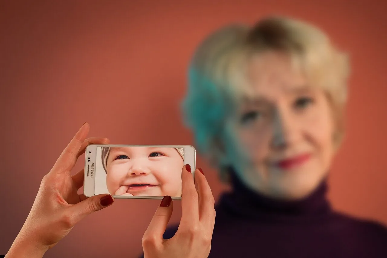 Older woman holding phone with baby photo representing biological vs chronological age