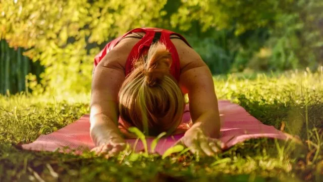 Woman doing gentle yoga exercise outdoors for hidradenitis suppurativa
