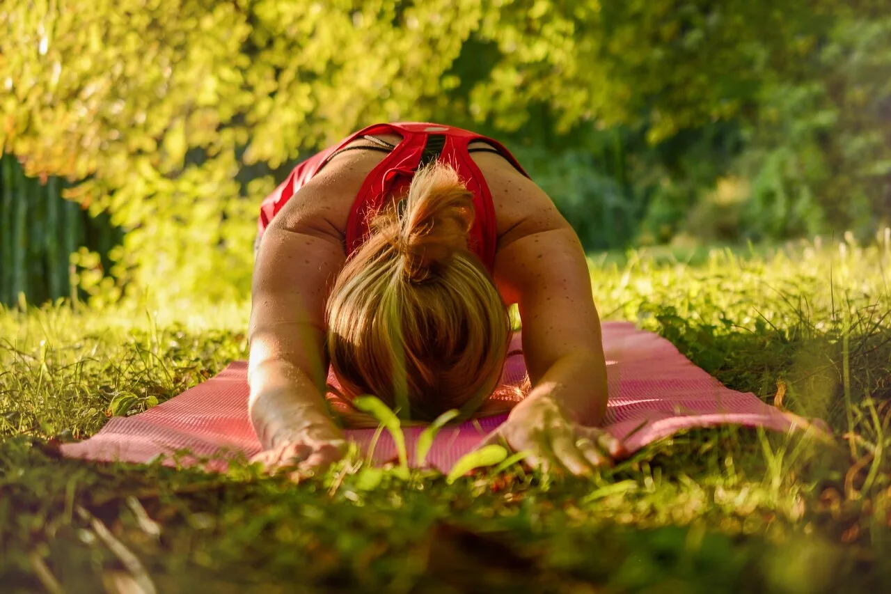 Woman doing gentle yoga exercise outdoors for hidradenitis suppurativa