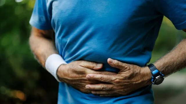 Runner holding side in pain from side stitch during exercise