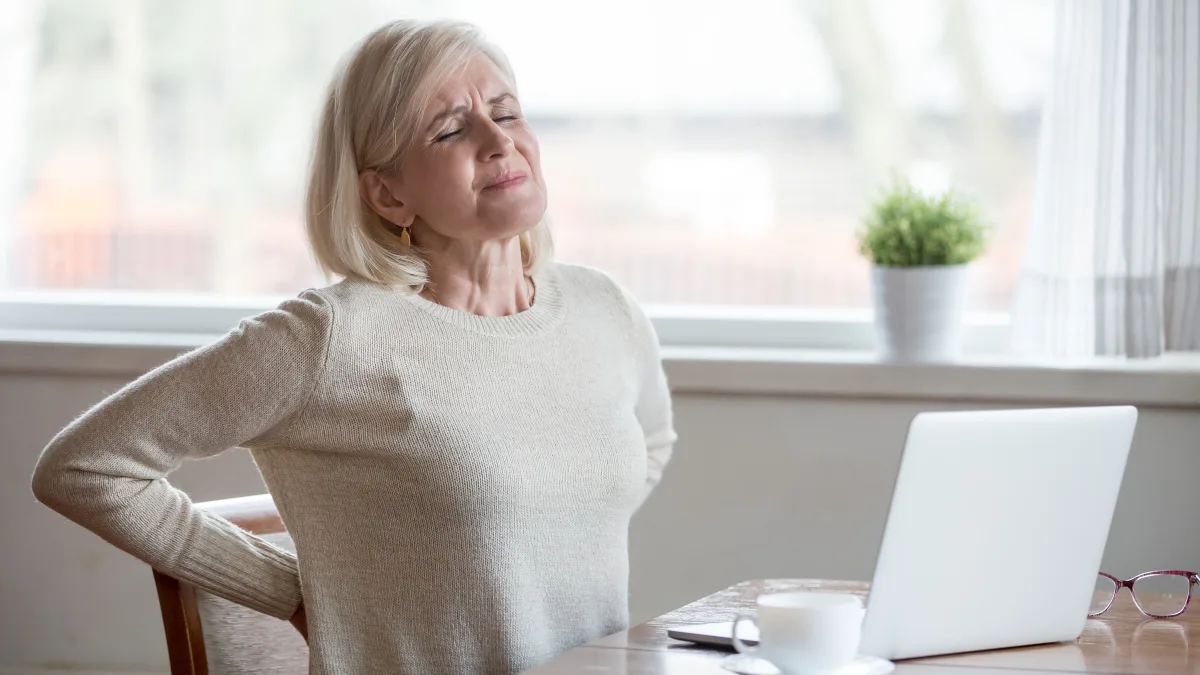 Woman experiencing back pain and chronic inflammation despite healthy lifestyle habits
