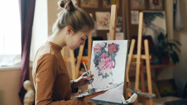 Woman painting in art studio representing how creativity supports mental wellness and well-being