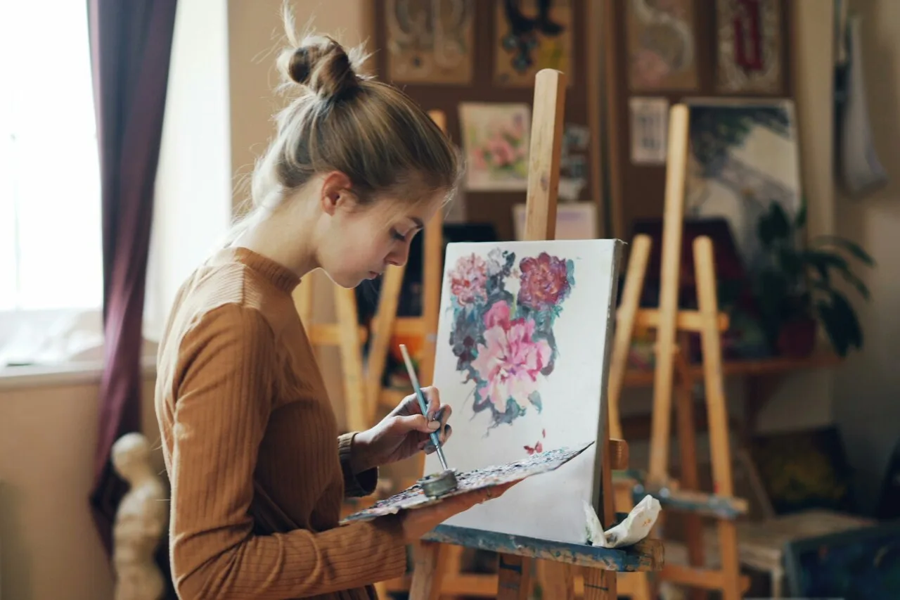 Woman painting in art studio representing how creativity supports mental wellness and well-being