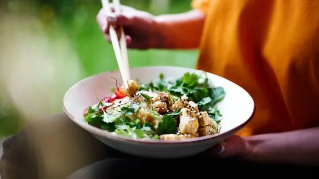 Person mindfully eating a healthy bowl representing intuitive eating without tracking macros