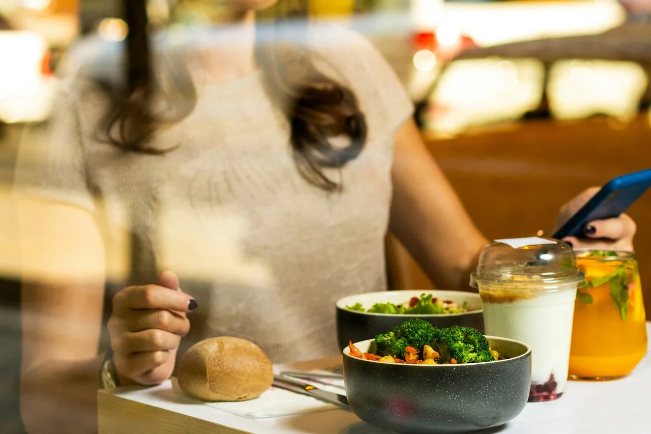 Woman using phone app to track healthy eating for Noom weight loss program