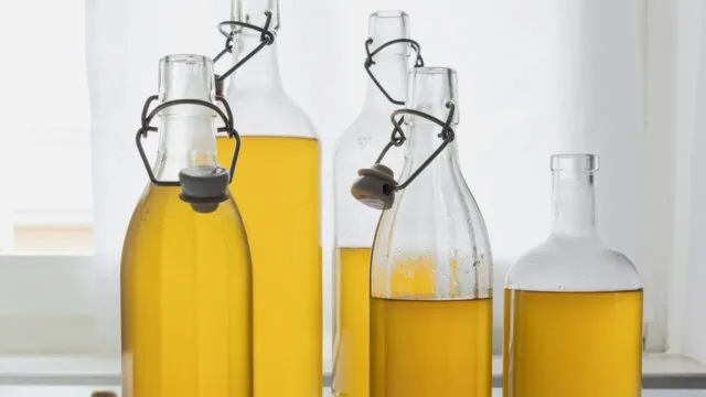 Glass bottles of seed oil representing health effects of cooking oils