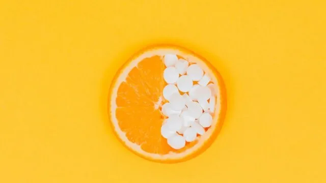Orange slice with vitamin C supplement pills representing natural anxiety relief