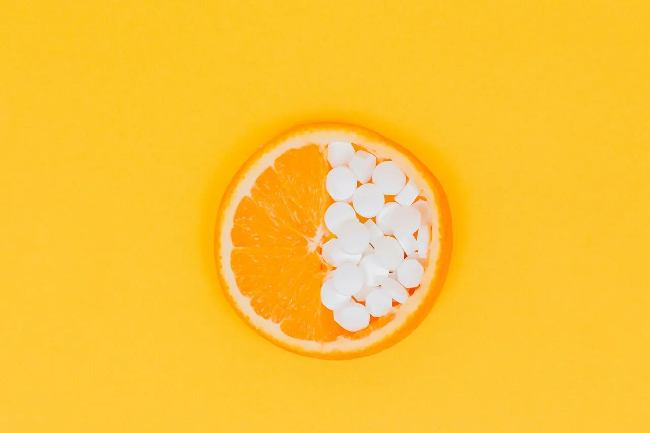 Orange slice with vitamin C supplement pills representing natural anxiety relief