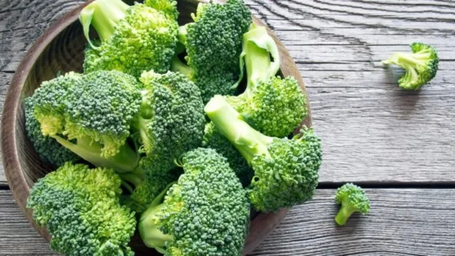 Fresh broccoli florets in a wooden bowl representing cruciferous vegetables that support liver detoxification and natural breast cancer prevention