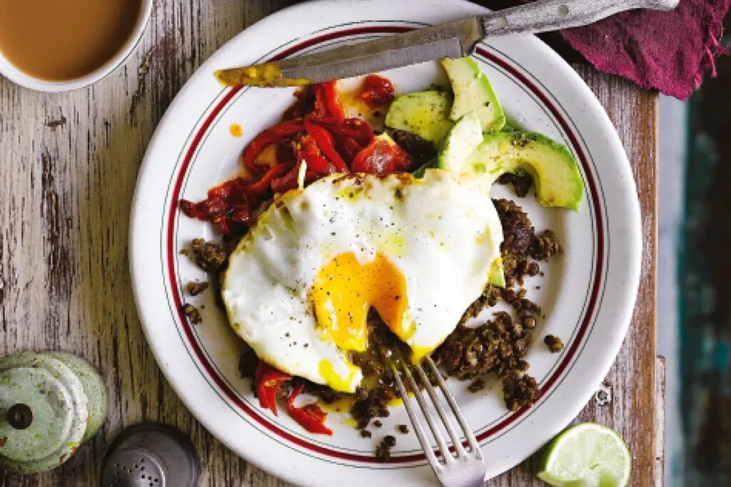 A nutritious high-protein meal featuring fried eggs, lentils, roasted peppers, and avocado — representing the balanced nutrition approach essential for building a lean, ripped physique.
