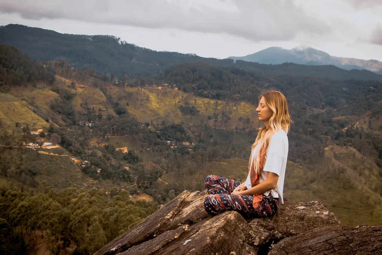 Woman practicing mindful self-care in nature, supporting holistic wellness, stress relief, better sleep, and body awareness.