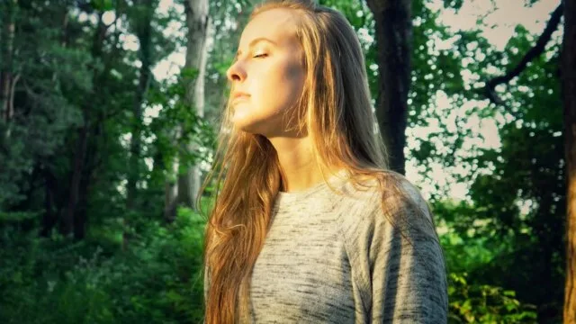 Woman practicing mindfulness meditation outdoors to ease anxiety disorder symptoms