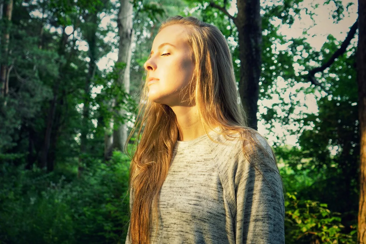 Woman practicing mindfulness meditation outdoors to ease anxiety disorder symptoms