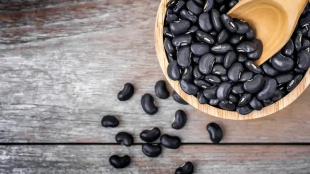 Black beans in a wooden bowl shown to be among the best legumes for blocking cancer spread and inhibiting MMP enzymes