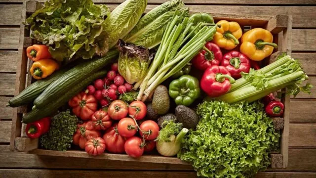 Wooden crate filled with fresh organic vegetables to support gut microbiome health and reduce pesticide exposure