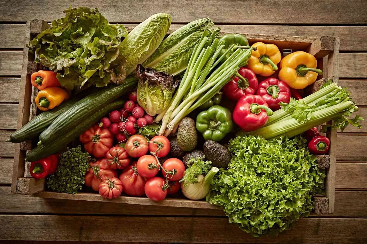 Wooden crate filled with fresh organic vegetables to support gut microbiome health and reduce pesticide exposure