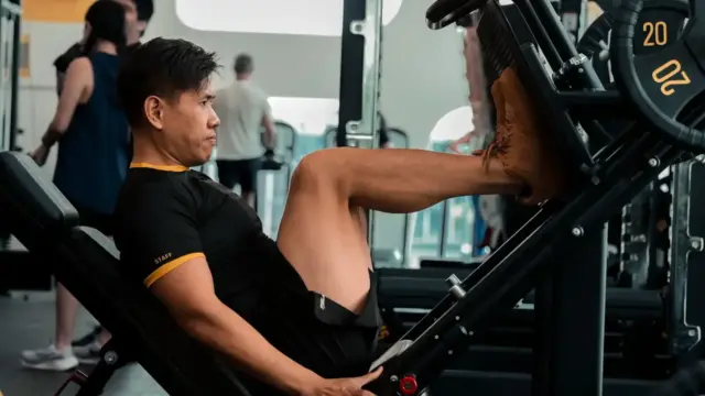 Man performing leg press exercise in gym to build lower body strength and muscle mass