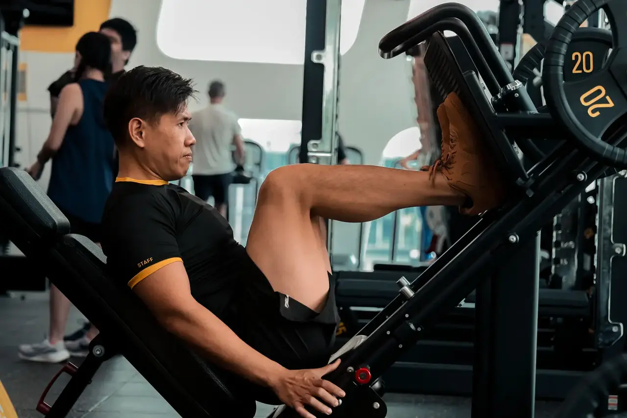 Man performing leg press exercise in gym to build lower body strength and muscle mass