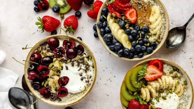 Three oatmeal breakfast bowls topped with fresh berries, seeds and fruit as a diabetes-friendly blood sugar controlling meal