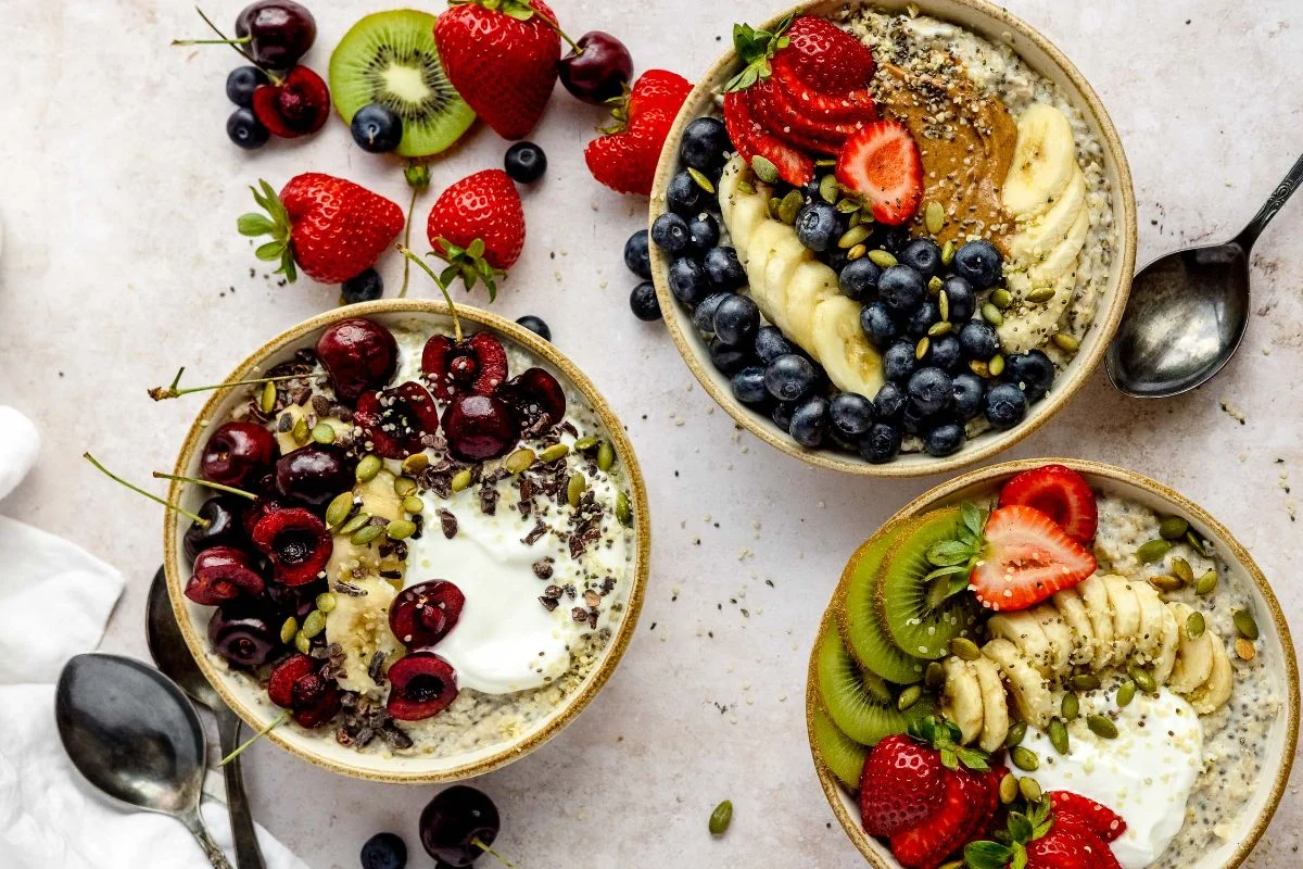 Three oatmeal breakfast bowls topped with fresh berries, seeds and fruit as a diabetes-friendly blood sugar controlling meal