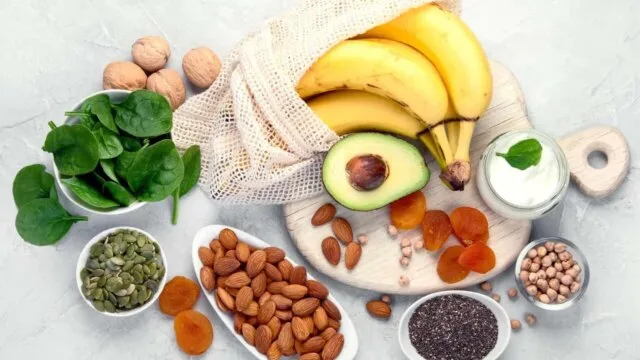 Potassium-rich foods including bananas, avocado, spinach, almonds and seeds arranged to illustrate how to balance sodium and potassium intake